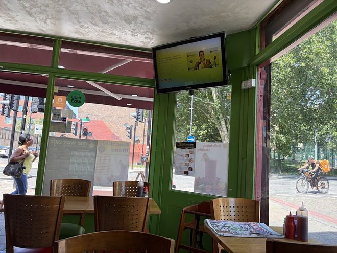 The window corner with green frames and the street outside