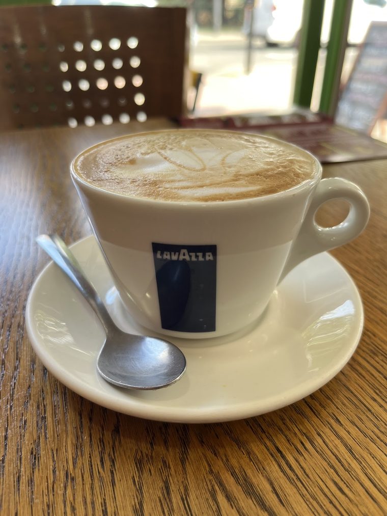 A cappuccino with a spoon on the saucer